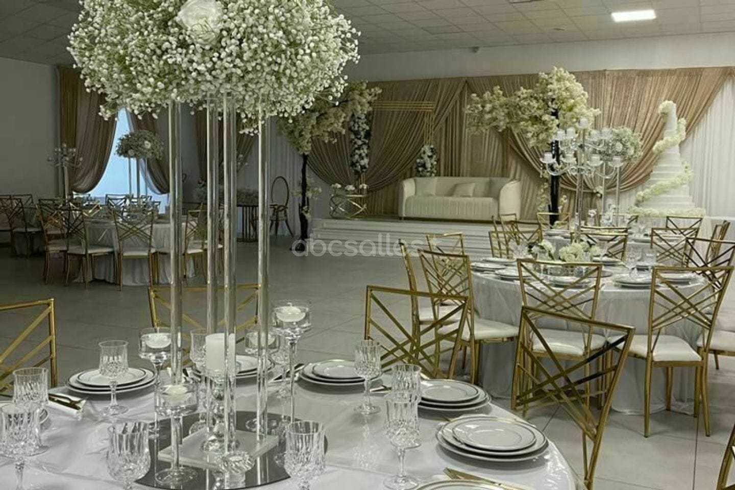 Centres de table en gypsophile sur colonnes de verre, salle prête pour la soirée.