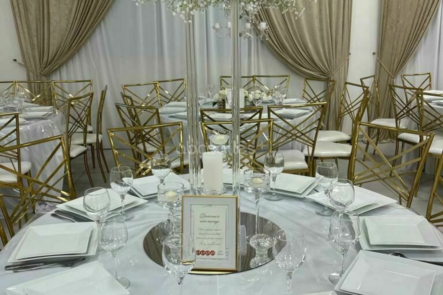 Table nappée de champagne, assiettes carrées et carton de menu.